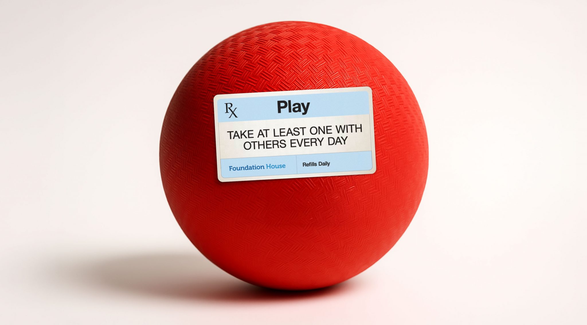 Play Rx at Foundation House: red kickball with prescription label—‘Play, take at least one with others every day’—symbolizing community-based recovery.