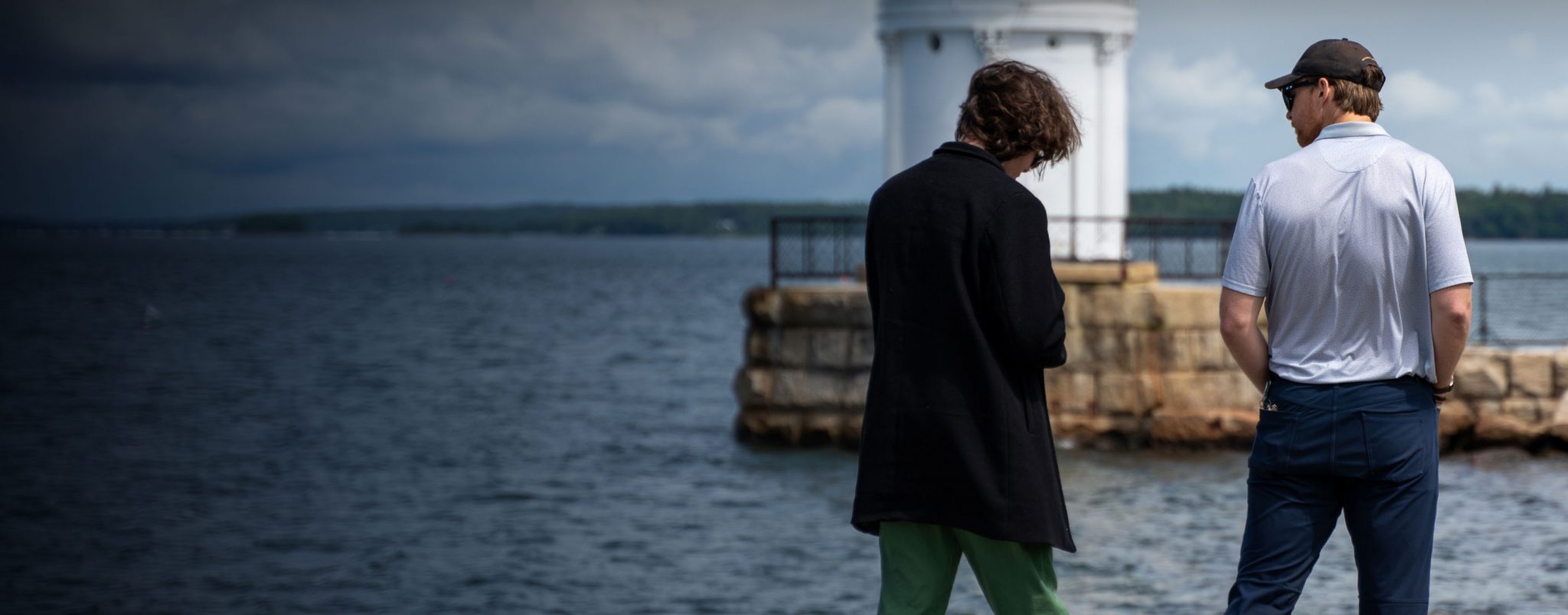 Two men talk about recovery while looking at the ocean in front of them